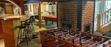 game room with air hockey, wood burning fireplace, wet bar with fridge and sink