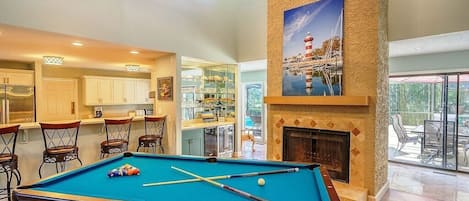 The Den with pool table and wet bar that has an ice maker and wine fridge below.