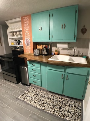 The cottage kitchen with live edge pine countertop and new SS appliances