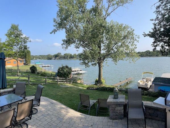 Tranquil patio with raised views flows to lake shore with two piers & fire pit