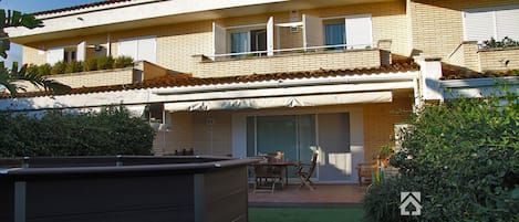 Vistas piscina, porche y casa desde el jardín.