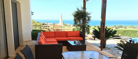 Large covered patio for dining and lounging with panoramic view of the sea.