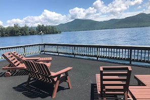 The deck of the boat house with lounge chairs and picnic table.