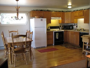 Fully furnished kitchen with dining area. Access to patio on left