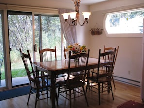 Dining room table with seating for 6, patio with woods  behind