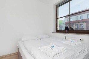 White and elegant bedroom with comfortable double bed, where the guests can rest.