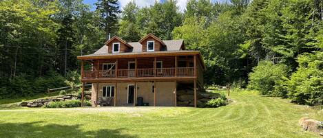 Mountainside cabin surrounded by woods. 