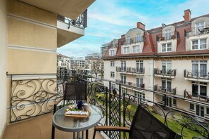 A balcony with chairs and a table provides the perfect place to enjoy the view.