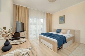 A bright space with a double bed and a flat-screen TV.