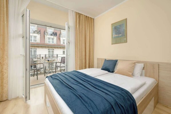 Cosy bedroom area with double bed. The room leads out onto a balcony.
