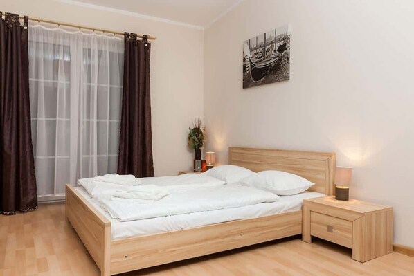 Wooden and atmospheric living area with comfortable bed for two people and functonal cabinet.
