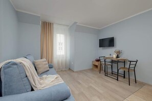 A cozy seating area with a grey sofa and neutral pillows. Soft lighting adds a warm and inviting touch.