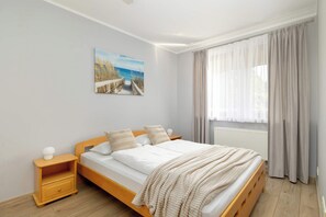 A bright bedroom with a comfortable double bed with white linen.