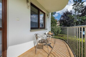 Furnished balcony overlooking green surroundings.