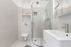 Functional and modern bathroom with comfortable shower, mirror, welcoming toiletries set and hair dryer.