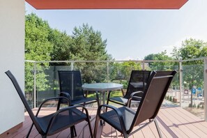 Spacious terrace with table and chairs.