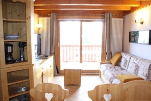 Salon séjour donnant sur la balcon avec vue sur les sapins et la vallée