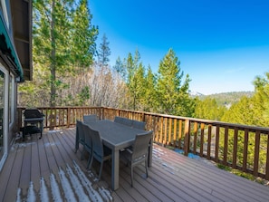 Access this upper deck through the living room with dining for 8, a gas BBQ, and beautiful forest views