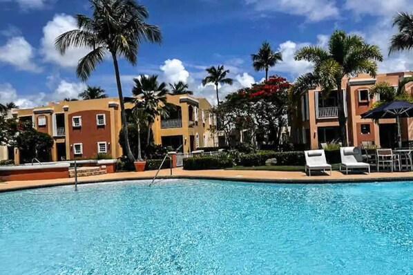 Enjoy a crystal clear swimming pool surrounded by palm trees
