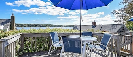 porch overlooking cove with table, chairs and umbrella