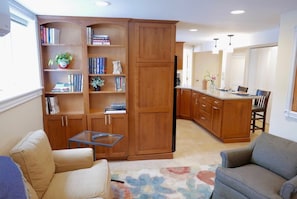 View from entrance across living space into kitchen area, TONS of reading material & books on DC 