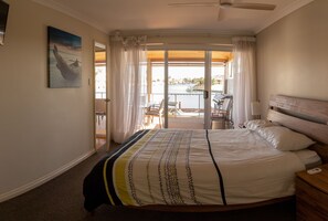 Main bedroom (queen bed) with ceiling fan and tv - view to canal