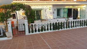 front entrance through wooden arch way overflowing with passion fruit 