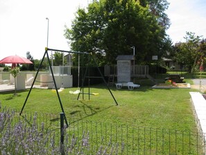 Jardin clos avec portique, maisonnette bois-tobogan-bac à sable.