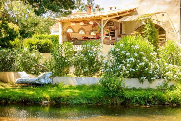 Terrasse et jardin ensoleillé avec vue sur la rivière