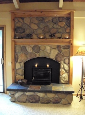 Stone and timber fireplace with wood burning insert - keeps the main room toasty