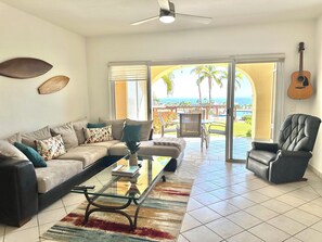 Living room with idyllic ocean view and steps away from the pool.