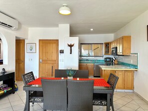 View from living room looking at main entrance door, kitchen, dining area