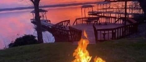 Outdoor fire pit as the sun sets over the lake 