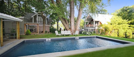 Pool with main house and barn/cottage in background.