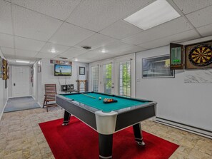 Game room has music and TV set up, and a door to walk out to the covered patio.