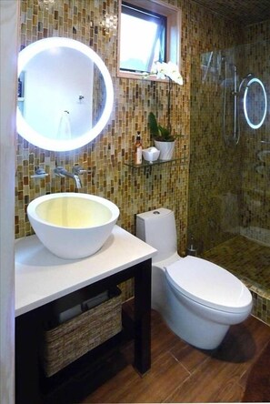 The modern, stylized bathroom features a gorgeous large rain-shower.