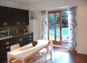 Fully equipped kitchen with French doors that open out to the pool and patio.