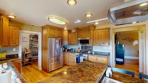 Large kitchen has gas range, French door fridge, microwave, granite counters
