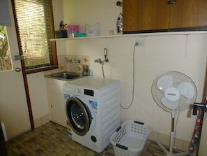 Laundry with front loader with laundry liquid and fabric softener, mop and broom