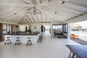 Kitchen with see through to living room (left behind), front porch (middle).