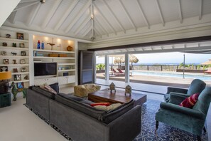 Living room indoors overlooking pool and ocean. 
