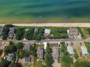 drone view of neighborhood and property's proximity to the bay/ beach