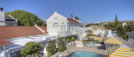 Birds eye view of the pool area, 8 chaizes, dining table outside barbeque