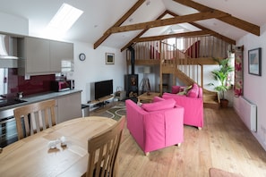 The airy and sunny open plan living area with stairs leading up to the mezzanine