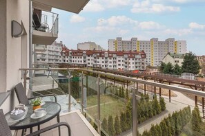 A view of an urban neighborhood, showcasing well-maintained buildings and a green park area with walking paths.