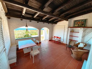 The front patio with the dining table and the straw chairs. 