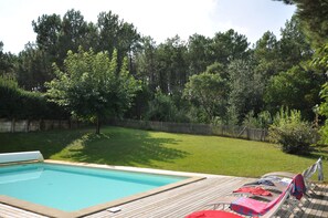 Blick vom Pool auf den Garten und Pinienwald