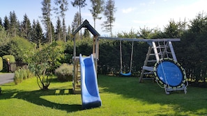 Spielturm im Garten und Trampolin