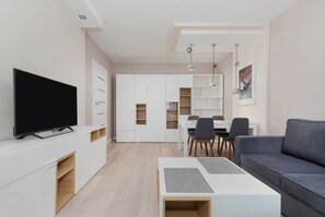 A comfortable living room with a gray sofa, TV, and coffee table, arranged in a simple and functional layout.
