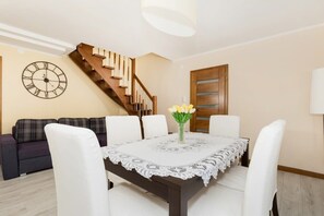 Wooden table behind which you can see the wooden staircase.